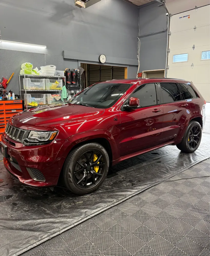 Red SUV freshly detailed inside auto detailing shop