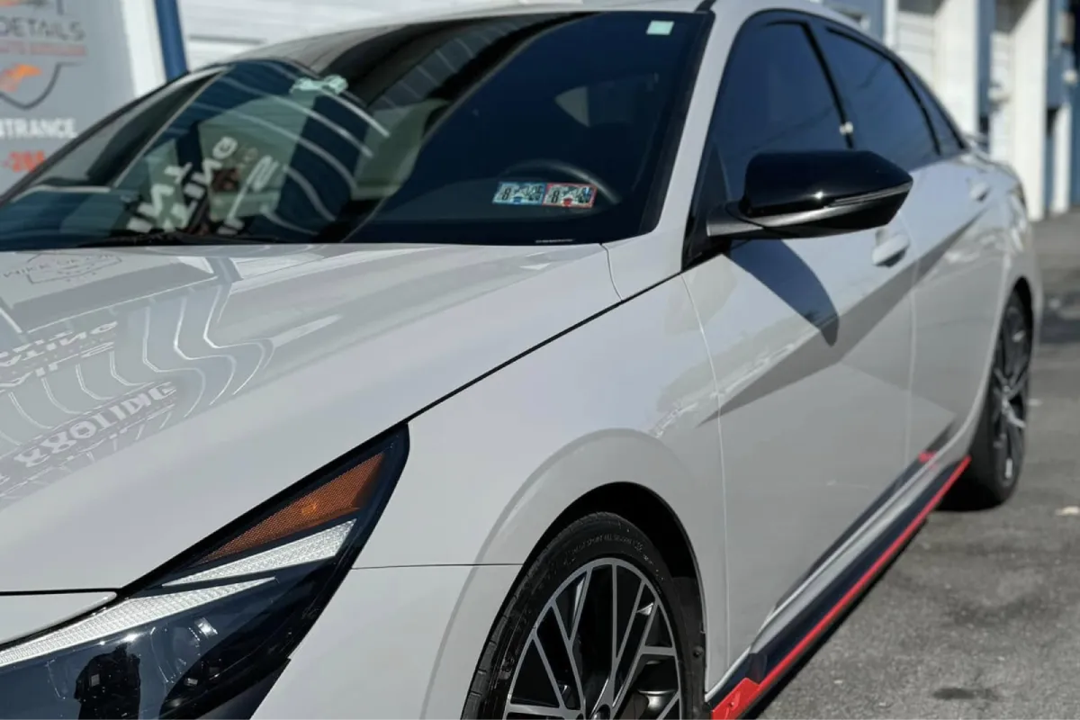 Close-up of a car with red accents, showcasing the side and front view.