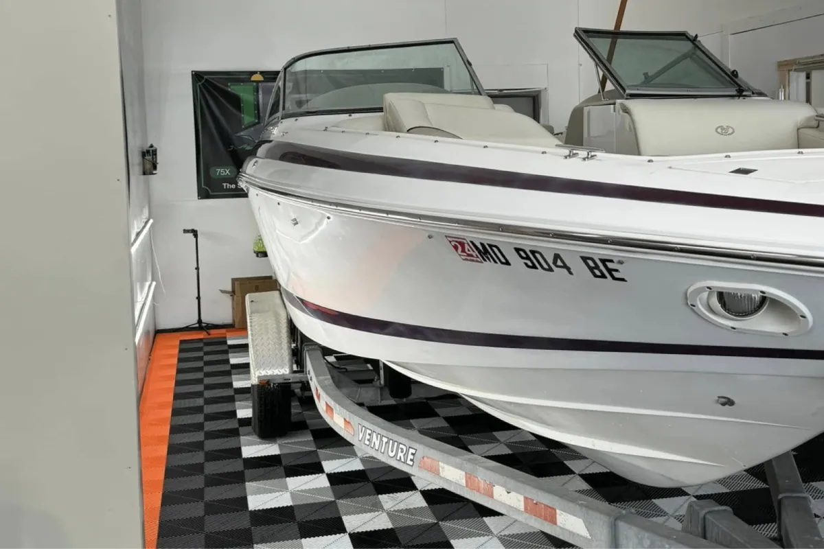 White boat on trailer inside a detailing shop