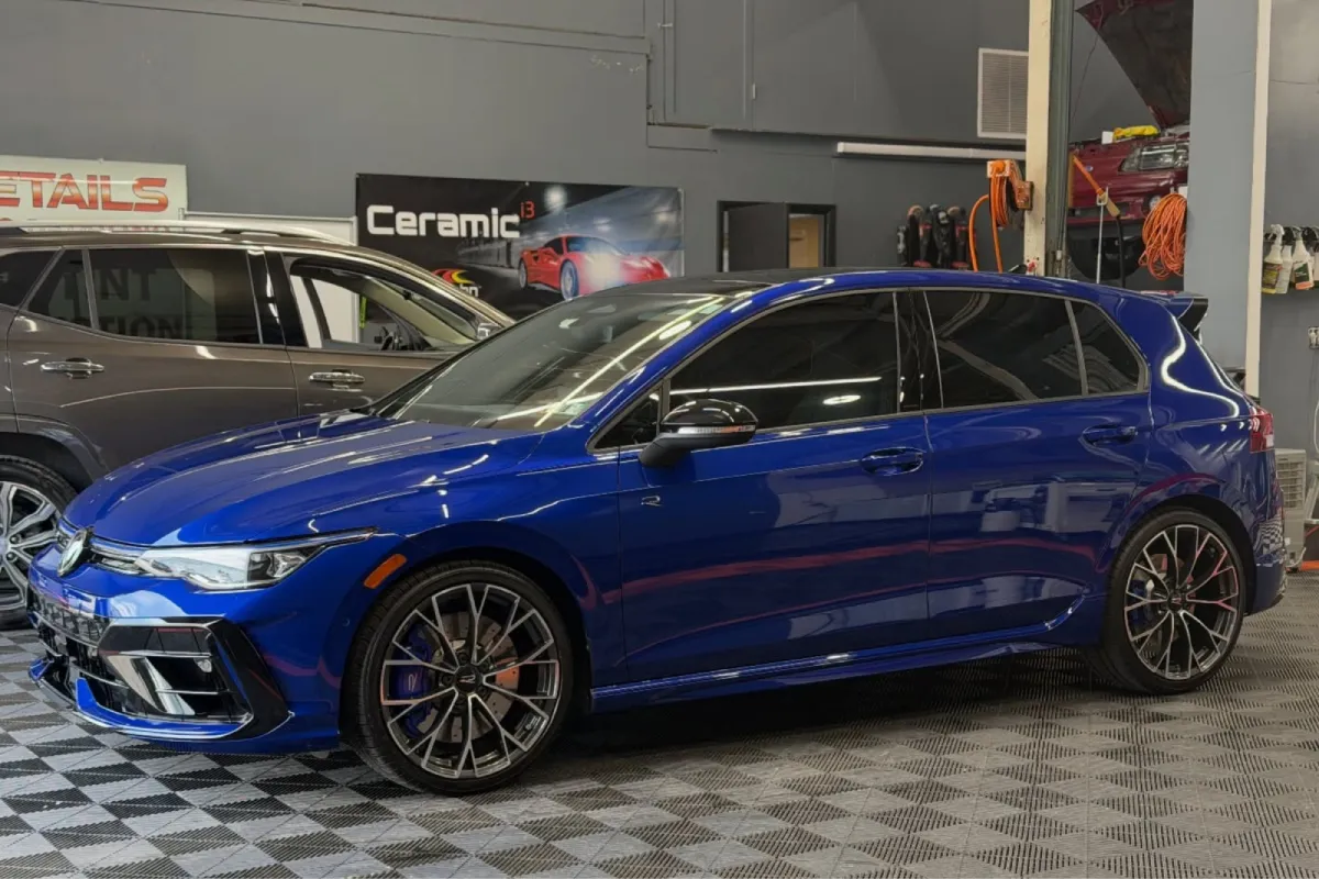 Blue car with paint protection film in detailing shop.