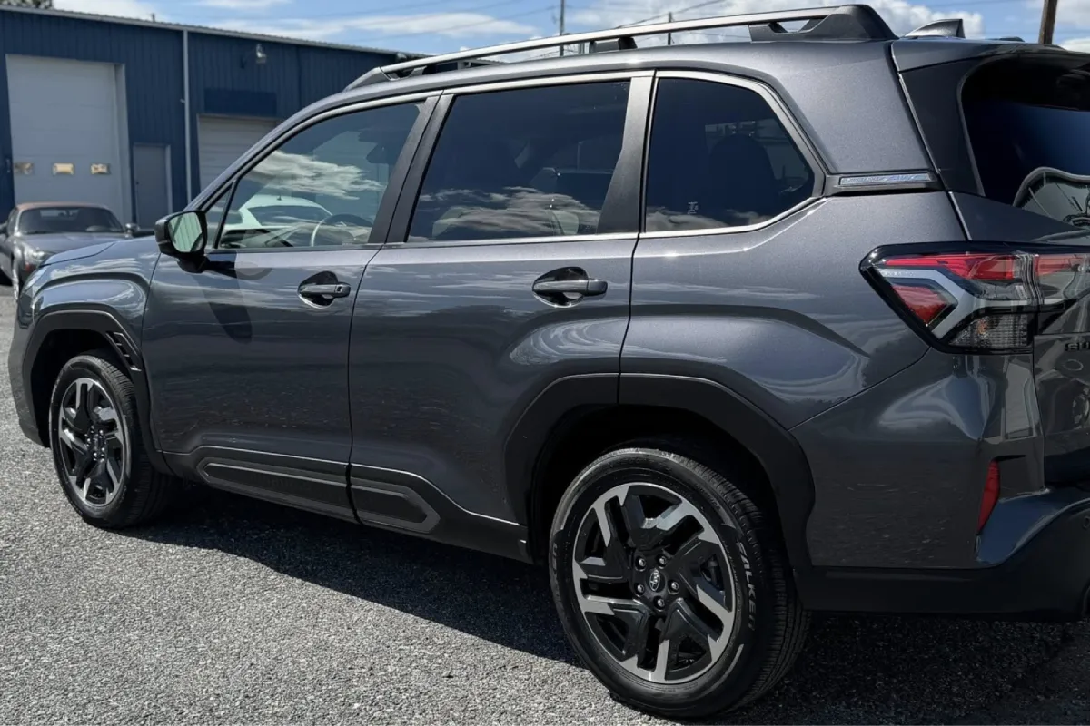 Gray SUV with dark tinted windows parked outside shop