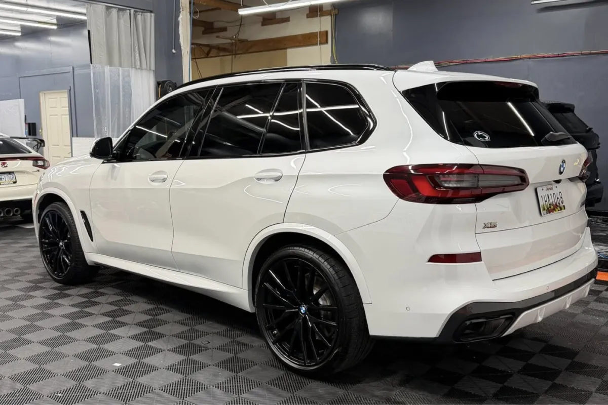 Side view of white BMW X5 with tinted windows.