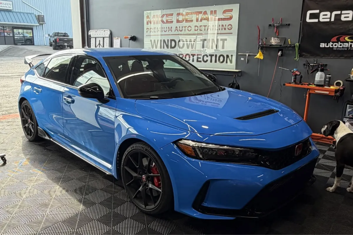 Blue Honda Civic protected with ceramic coating in a detailing shop.